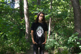 Young aboriginal man wearing black t-shirt depicting male chicken dancer in full chicken regalia, printed with white and metallic silver, colourfast water-based inks on a pre-washed soft cotton shirt. Unisex sizes S-2XL 