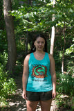 Young woman wearing hi-Dive blue t-shirt with woodland style painting of a Crane by Ojibwa artist Donald Chretien. Under the painting are the words: Our Water is Sacred. 5 colour, water-based silkscreen print on premium pre-washed soft cotton, Unisex size small